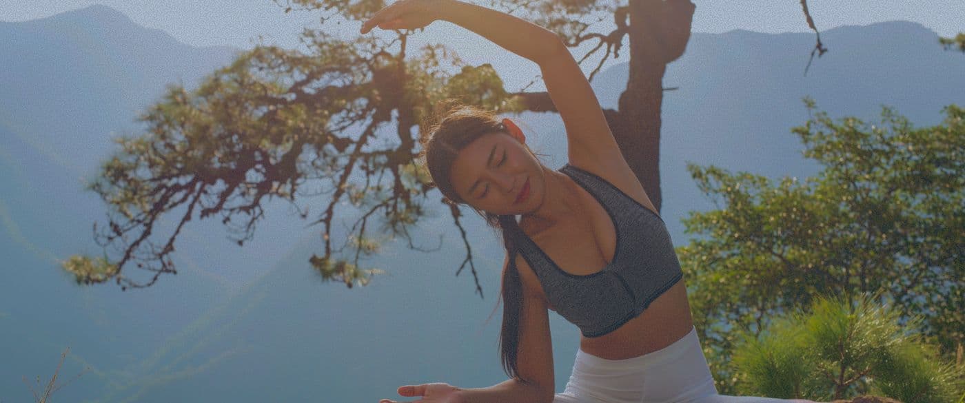Woman stretching outdoors against mountains