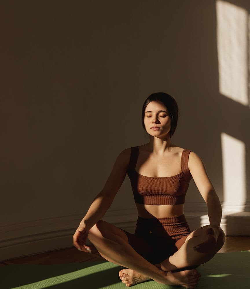 Woman meditating in a sunlit room
